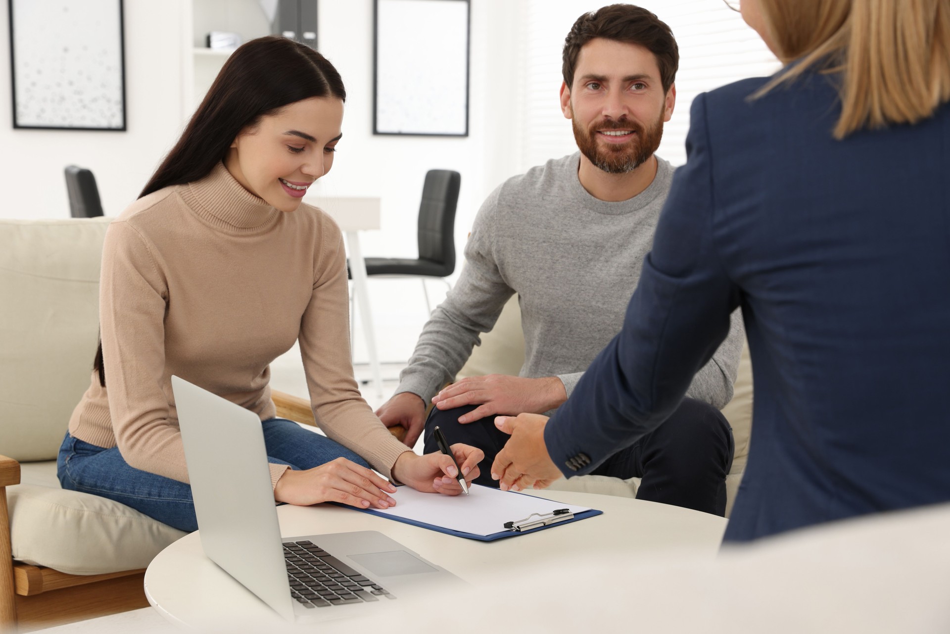 Couple signing contract in real estate agent's office