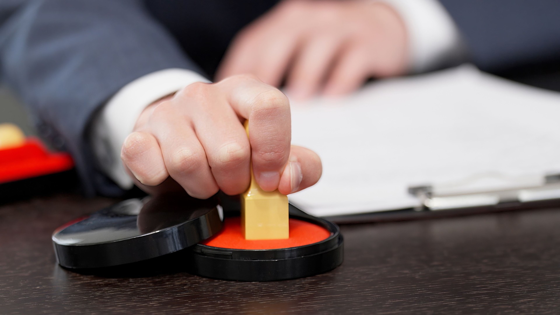 The hands of a businessman stamping a contract