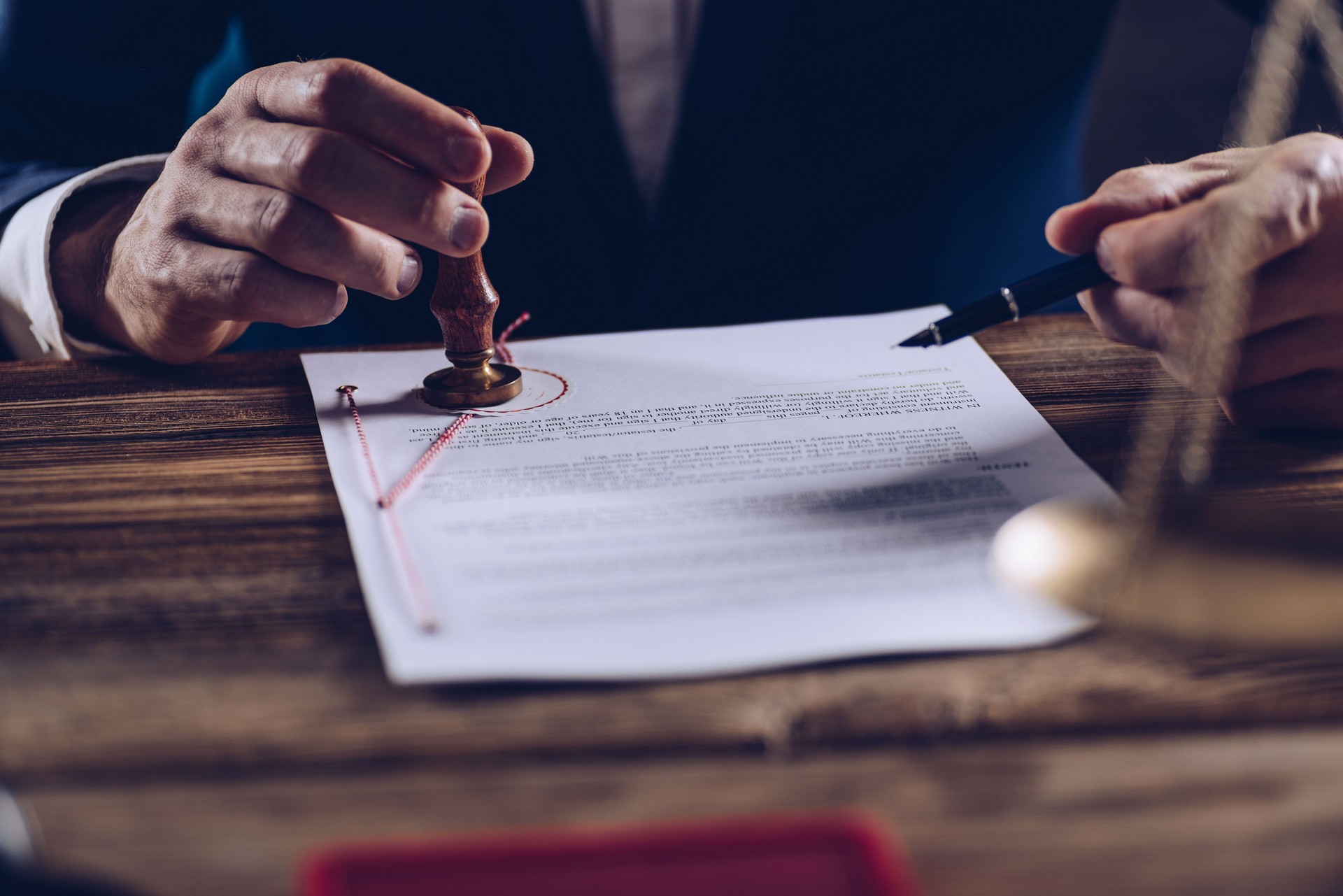 Male lawyer or notary stamping document at his office.